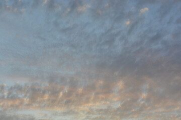 Colorful evening sky with dramatic clouds at sunset above rooftops, creating a peaceful and serene atmosphere