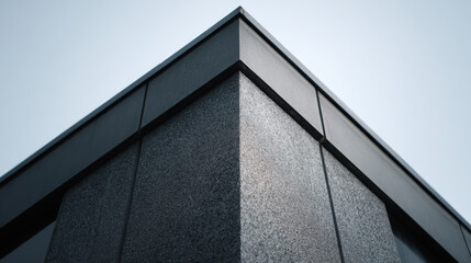 Fototapeta premium Modern building corner with textured rain screen facade under clear sky