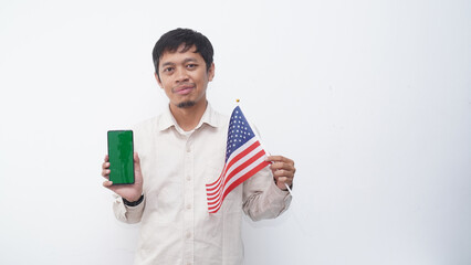 Asian Man holding green screen smartphone with USA flag at studio against white background