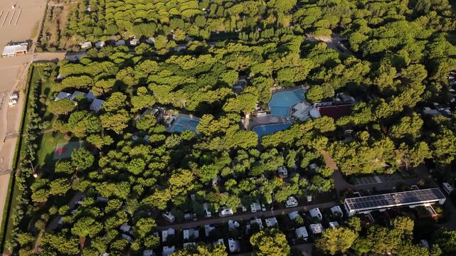 Aerial view of beachside camping with pools and pine trees in Cavallino Treporti, Italy
