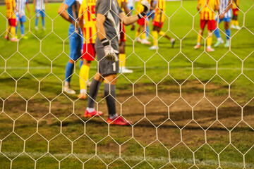 Football Goalkeeper Action Seen Through Net – Concept of Soccer and Sport