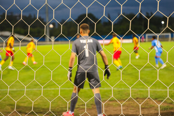 Football Goalkeeper Action Seen Through Net – Concept of Soccer and Sport