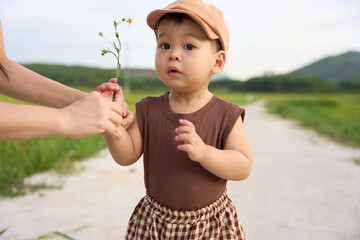 baby holding plant branch
