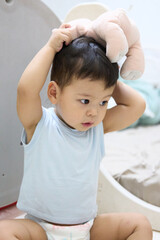 Fototapeta premium baby playing with teddy bear ears