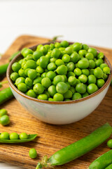 Fresh green pea pods with green peas on a wooden background. Sweet green peas. Green pea beans vegetables. Vegan. healthy vegetable. Copy space