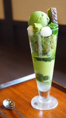 Elegant Japanese matcha parfait layered with green tea ice cream, mochi, whipped cream, soft lighting in Kyoto