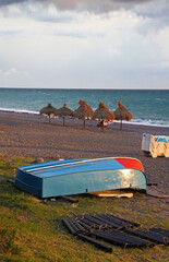 An overturned lifeboat on the shore of a sea beach