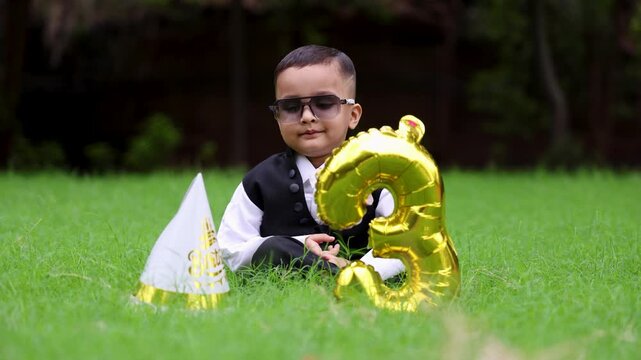 cute indian kid in birthday attire with awe expression on third birthday at outside