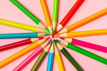 Fototapeta premium Colored pencils on a bright colored background. Equipment for coloring. Stationery for creativity.Back to school. Flatlay. Children's Creativity and Education. Rainbow.Space for text. Copy space.
