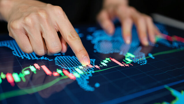 Photo of a persons finger points to a financial stock market graph on a digital world map display