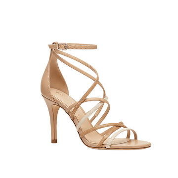 A stylish beige high heel sandal with multiple delicate straps is presented on a stark black background.