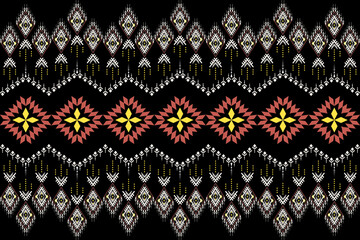 An Ikat-style digital print pattern featuring geometric diamond and zigzag motifs arranged in horizontal bands of yellow, dusty rose, and white on a solid black background.