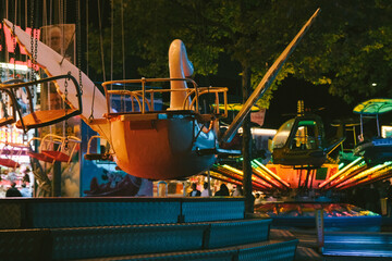 Children's carousels lit up. Luna Park. Evening or nighttime amusement park.