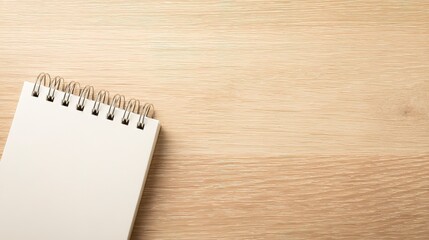 An open blank spiral notebook rests on a textured wooden surface
