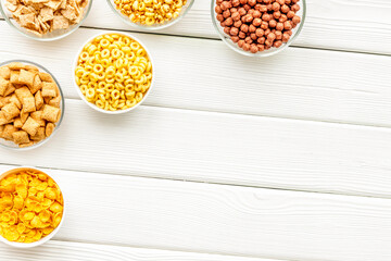 Cereals and flakes from corn and oat on white wooden background top view mockup