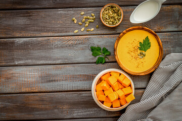 Pumpkin soup on wooden background top-down copy space
