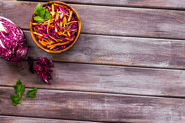 Healthy vegan salad with red cabbage on wooden kitchen table top view copy space