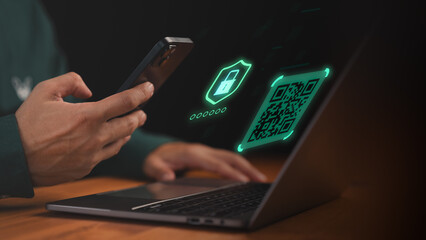 Man using smartphone and laptop with digital QR code and security icon, representing online payment, two factor authentication, data protection, cyber security, fintech and secure transaction.
