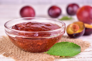 Pink plum jam in a glass bowl. Close-up.
