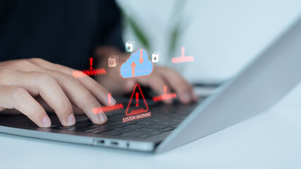 Hand typing on a laptop with digital cloud warning and alert icons, representing cloud system error, cybersecurity risk, data breach prevention, and online information protection technology concept.