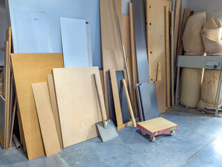 Workshop corner storage area filled with various wooden materials and construction supplies organized for easy accessibility. High quality photograph
