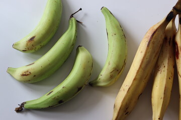 Raw and ripe Nendran plantains in bunches, showing ripening stages. Good for harvest and food themes