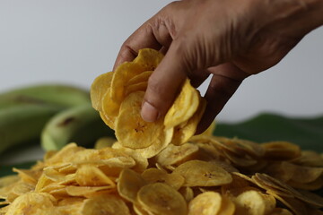 Golden plantain chips on green leaf, made from raw plantains. Kerala snack for comfort and taste