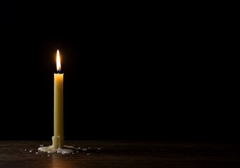 Single Lit Candle on Wooden Surface in Dark Room