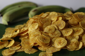 Golden plantain chips on green leaf, made from raw plantains. Kerala snack for comfort and taste