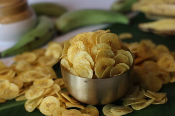 Crispy plantain chips in golden bowl, made from green plantains. Kerala snack for comfort and taste