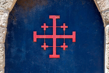 Close up of the Red Jerusalem Cross or Crusader Cross on the blue door of Saint John's Baptist Church in the old city of Acre, Akko Israel.
