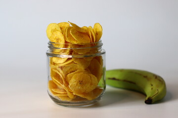 Plantain chips in jar with raw plantain, a South Indian snack ideal for comfort and homemade themes