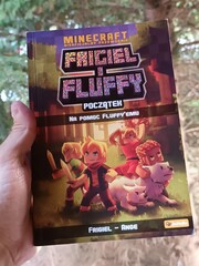 Naklejka premium Hand Holding a Minecraft-Themed Graphic Novel