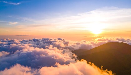 Fototapeta premium A breathtaking vista of a mountain peak above a sea of clouds at sunrise, showcasing a vibrant array of warm colors and a serene atmosphere.