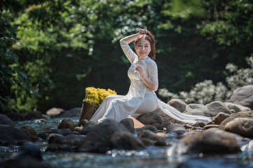 Beautiful Vietnamese Woman in Traditional White Áo Dài with Yellow Flower Basket