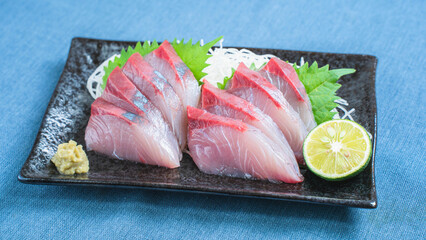 ハマチの刺身とすだちを添えた和食料理