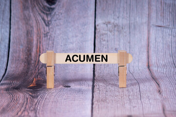 Acumen symbol. Single Wooden stick supported by Clothespins, beautiful Light Orange tone highlight Wooden Texture Background. Business and Acumen concept with copy space