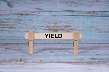 Yield symbol. Single Wooden stick squeezed by Clothespins, Grungy blue Wooden Texture Background. Business and Yield concept with copy space
