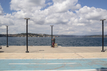 Man in hat standing alone by the water on scenic pier from turkey