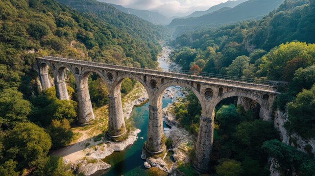 Stunning view of an ancient stone bridge spanning a lush river valley at sunrise