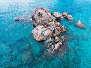 Fototapeta premium La Digue, Seychelles. Aerial view of sharp granite rock formations, transparent turquoise waters, and tropical shoreline.