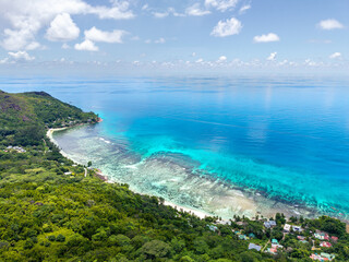 Naklejka premium Seychelles aerial view, Praslin Island. Lush green coastline, turquoise waters, and tropical hills creating a stunning and exotic island landscape.