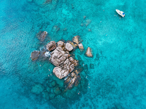 Seychelles aerial view, Praslin Island. Granite rock formations along a tropical shoreline with transparent turquoise waters and lush coastal vegetation. Exotic landscape.
