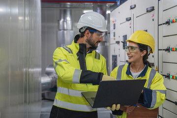 Foreman and Engineer Plan System Upgrade Construction foreman and engineering manager discussing plans while examining the existing industrial air conditioning system