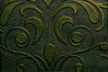 Emerald-colored wallpaper with a decorative plaster texture on the surface, featuring a pattern of curling leaves and flowers, designed for a boudoir