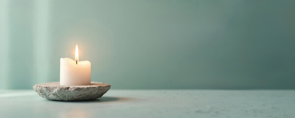Calm glowing candle on stone holder promotes social wellness, stress management. Visual aids in teaching mindfulness, anxiety relief, community improvement practices. Gentle reminder for personal