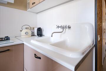 Kitchen sink area with classic kettle and modern coffee machine in a cozy home setting