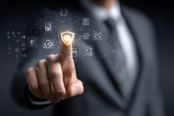 Businessman touching shield icon on virtual screen for cybersecurity concept