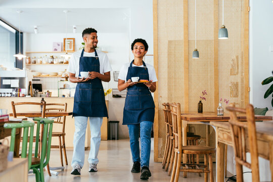 Barista and waiter working in a bar cafeteria shop - Powered by Adobe