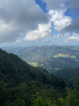 Moody Mountain Landscape in Castagno d&rsquo;Andrea &ndash; Cloudy Sky with Soft Sunlight Breaking Through Over the Lush Forested Hills of Tuscany&rsquo;s Apennines, Capturing a Calm and Atmospheric Scene